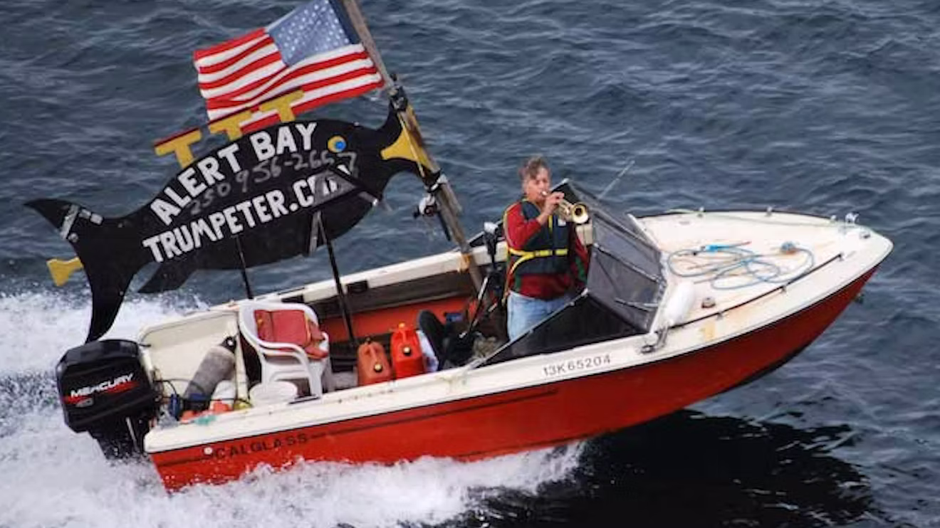 Jerry Higginson on his boat with trumpet